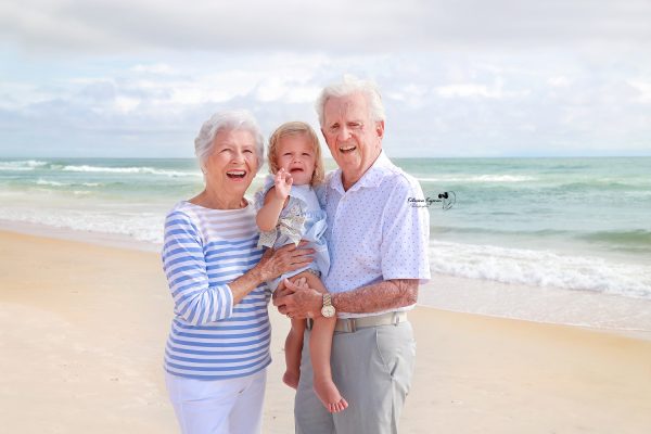 Family enjoying a joyful beach photography session, capturing candid moments of love, laughter, and togetherness by the ocean at sunset.
