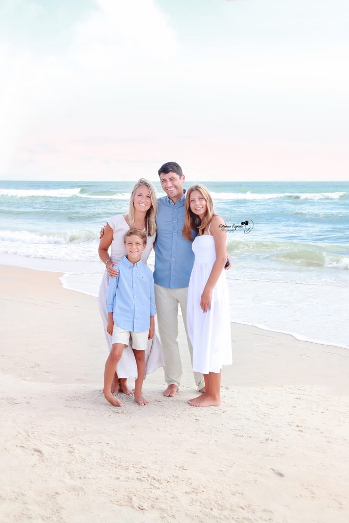 Parents and children laughing together during a family beach photography session at the shore.