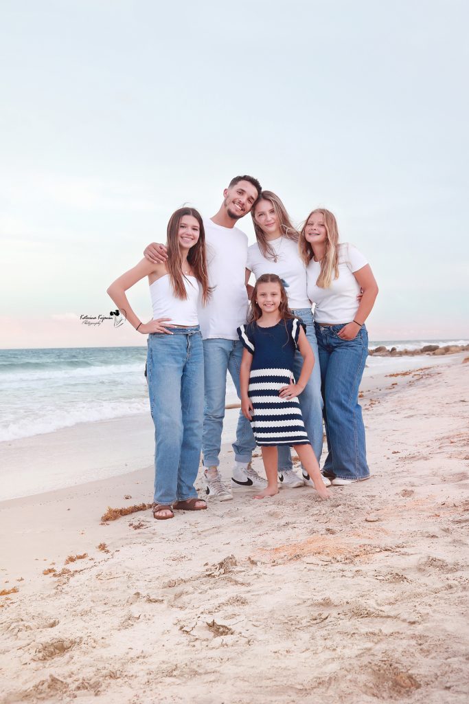 Joyful family playing by the ocean, captured in a scenic beach photography session.