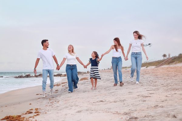 Candid family moments captured on the beach, with golden sunlight and waves in the background.