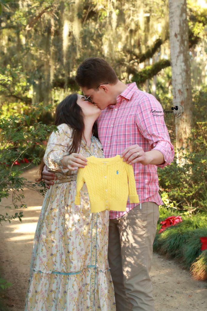 Close-up of a pregnant mother’s hands on her belly, highlighting the beauty and glow of maternity in a professional session.